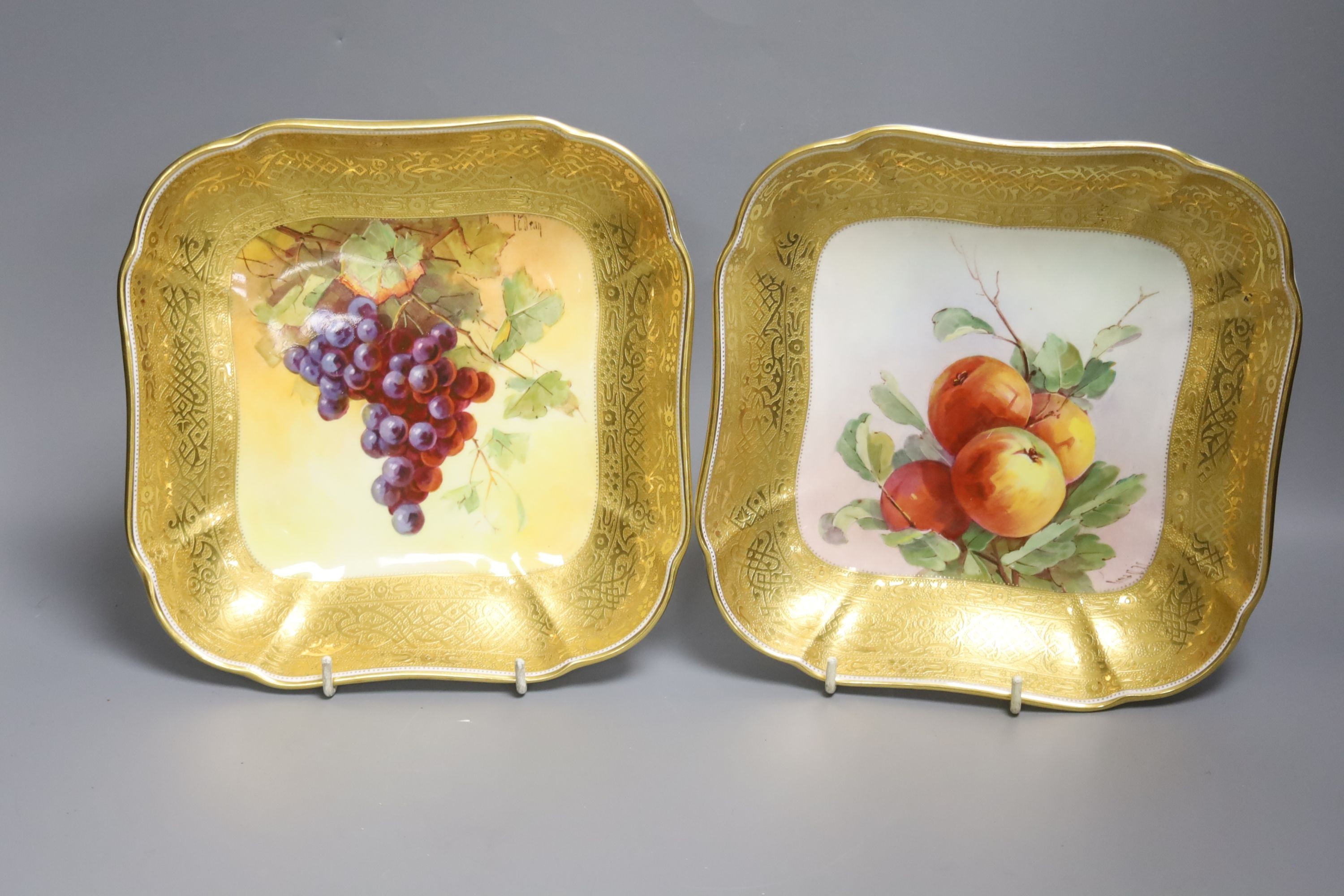 A pair of Minton’s fruit painted dishes of squared form, early 20th century, with tooled gilt borders, signed J C Dean, 21cm diameter.